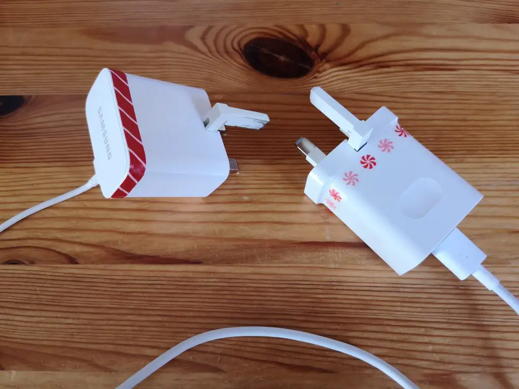 Two white chargers that have thin strips of washi tape wrapped round them, in two different patterns.