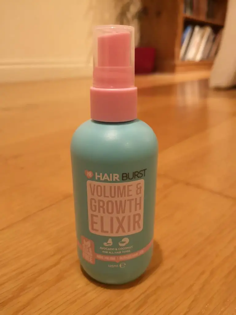 Hairburst Elixir bottle standing on a wooden floor