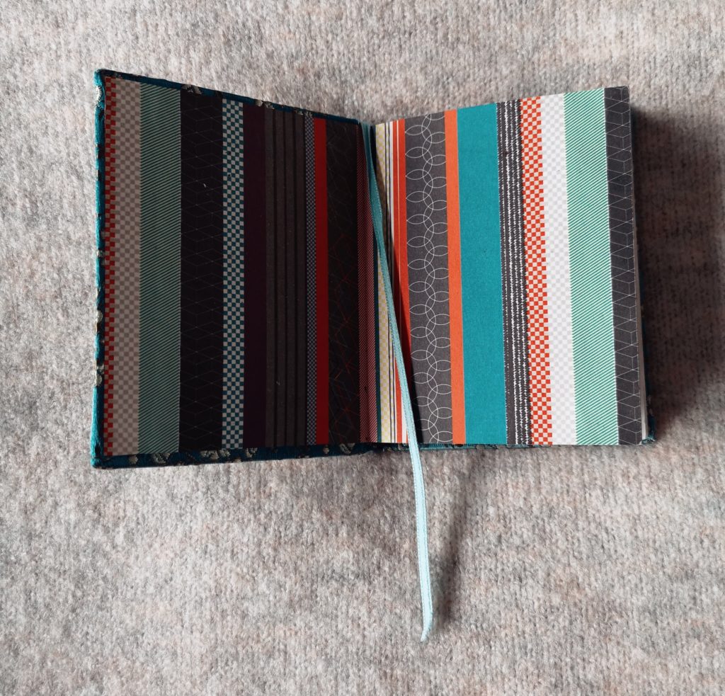 An open diary with a turquoise ribbon being used as a bookmark