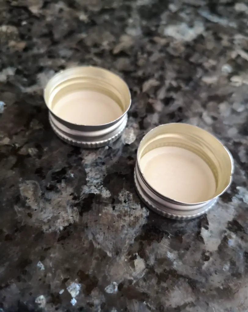 Two metal bottle lids.