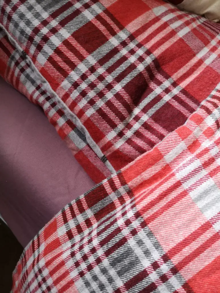 A close-up of my red tartan duvet cover over a purple sheet