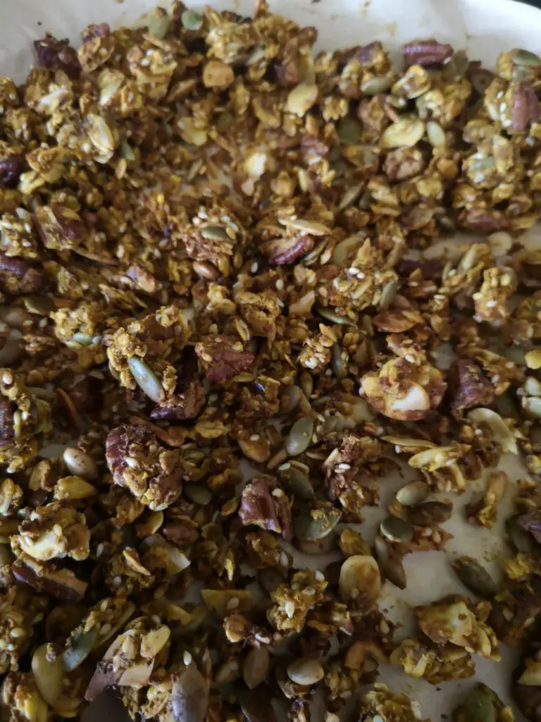 A close up of pumpkin spice granola on a baking sheet