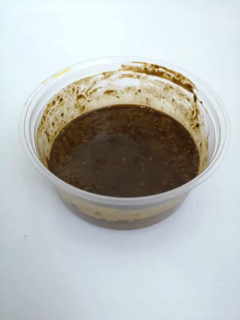 My brown, gloopy henna mixture in a plastic pot