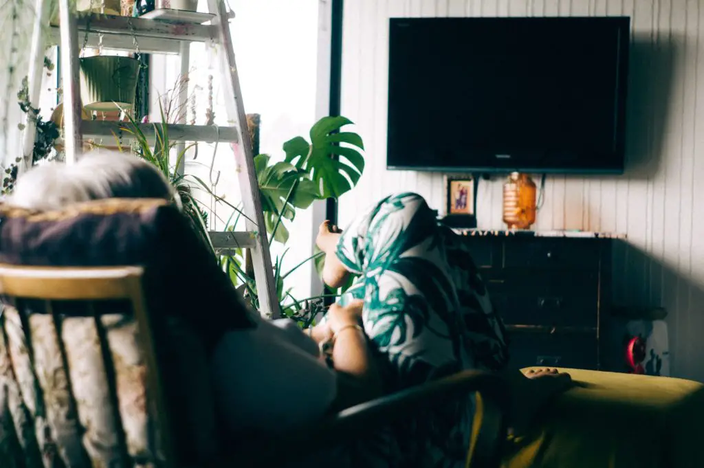 A woman sitting in an armchair in front of the TV.