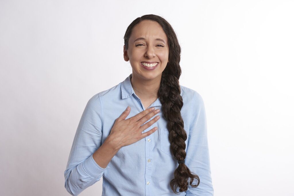 A woman with her hand on her chest where the thymus gland is