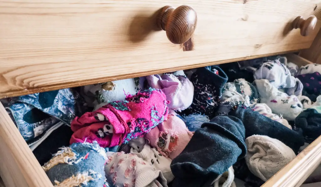 An open drawer full of short socks in various colours.