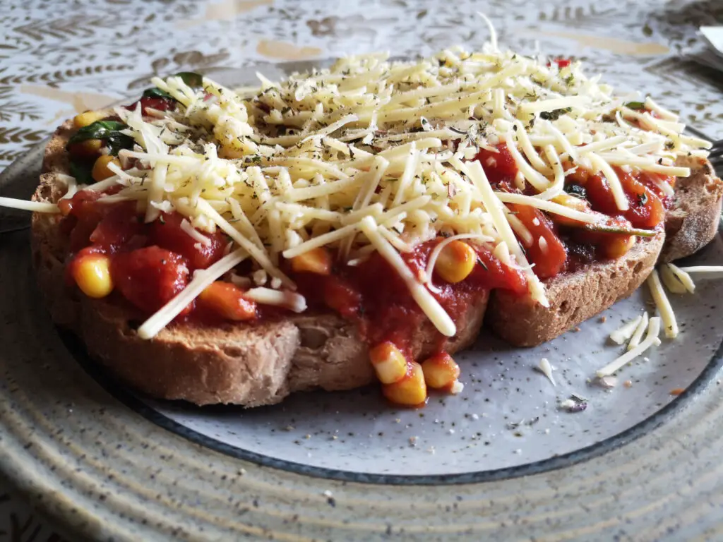 Mini toast pizza with toppings and cheese.