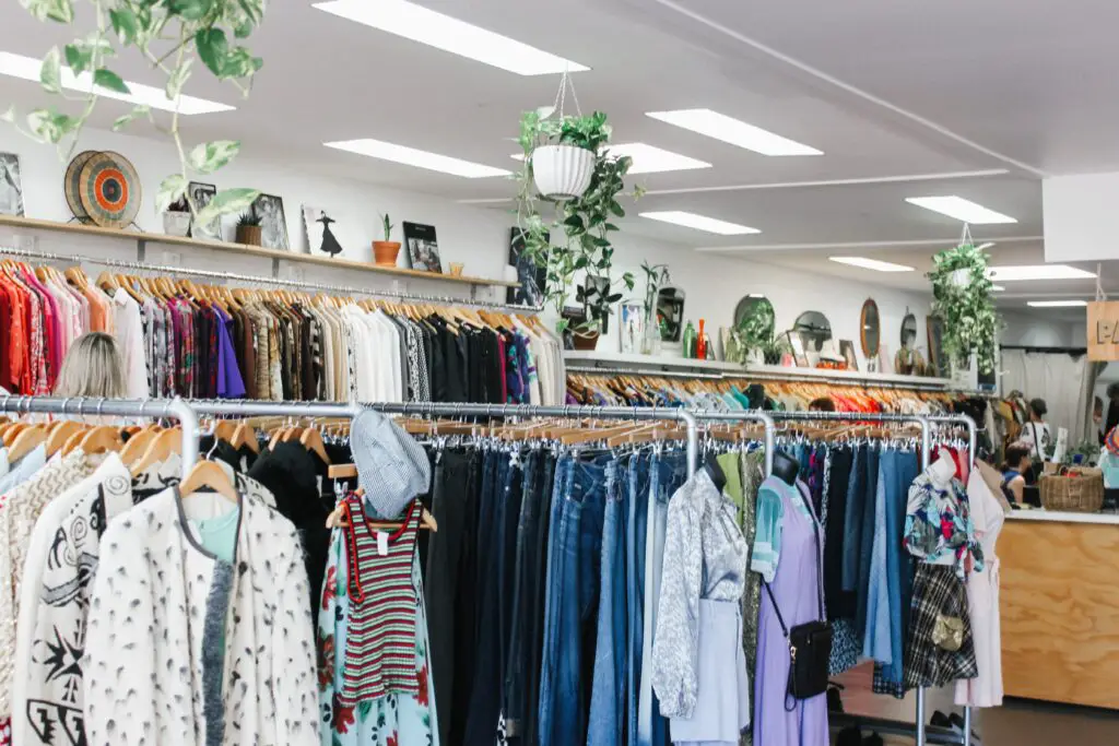 A charity shop with neat rails filled with clothes.