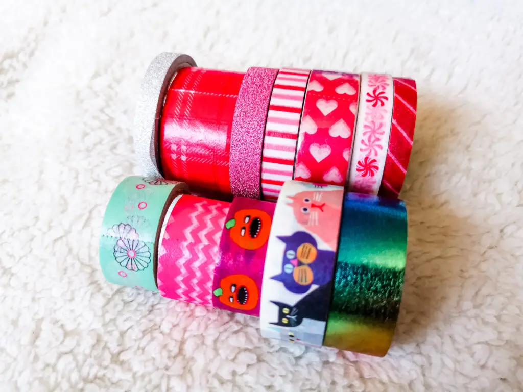Several rolls of colourful washi tape neatly lined up.