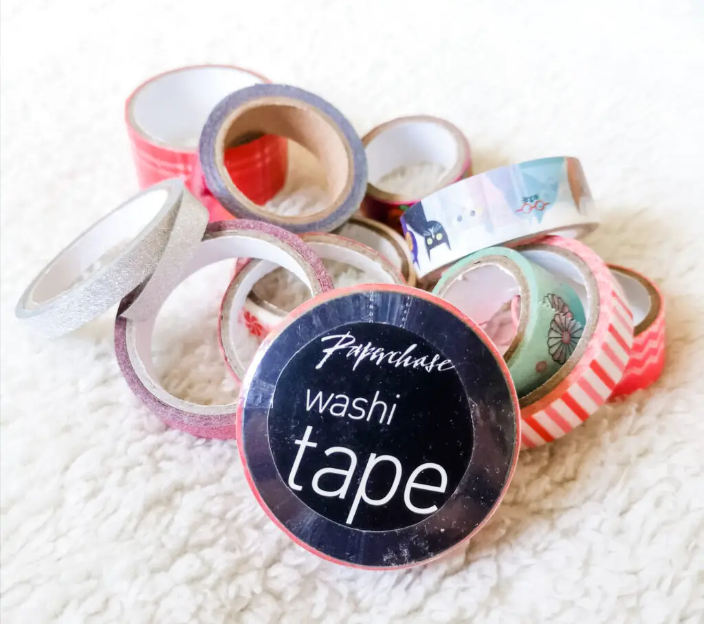 Various colourful rolls of washi tape jumbled up in a pile.