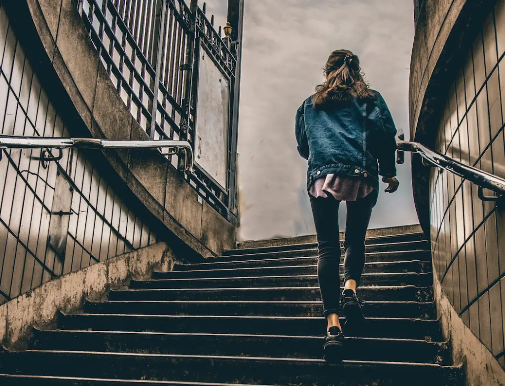 A woman walking up a flight of stairs.