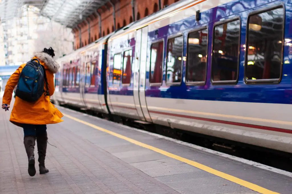 A woman running along the platform to catch a train