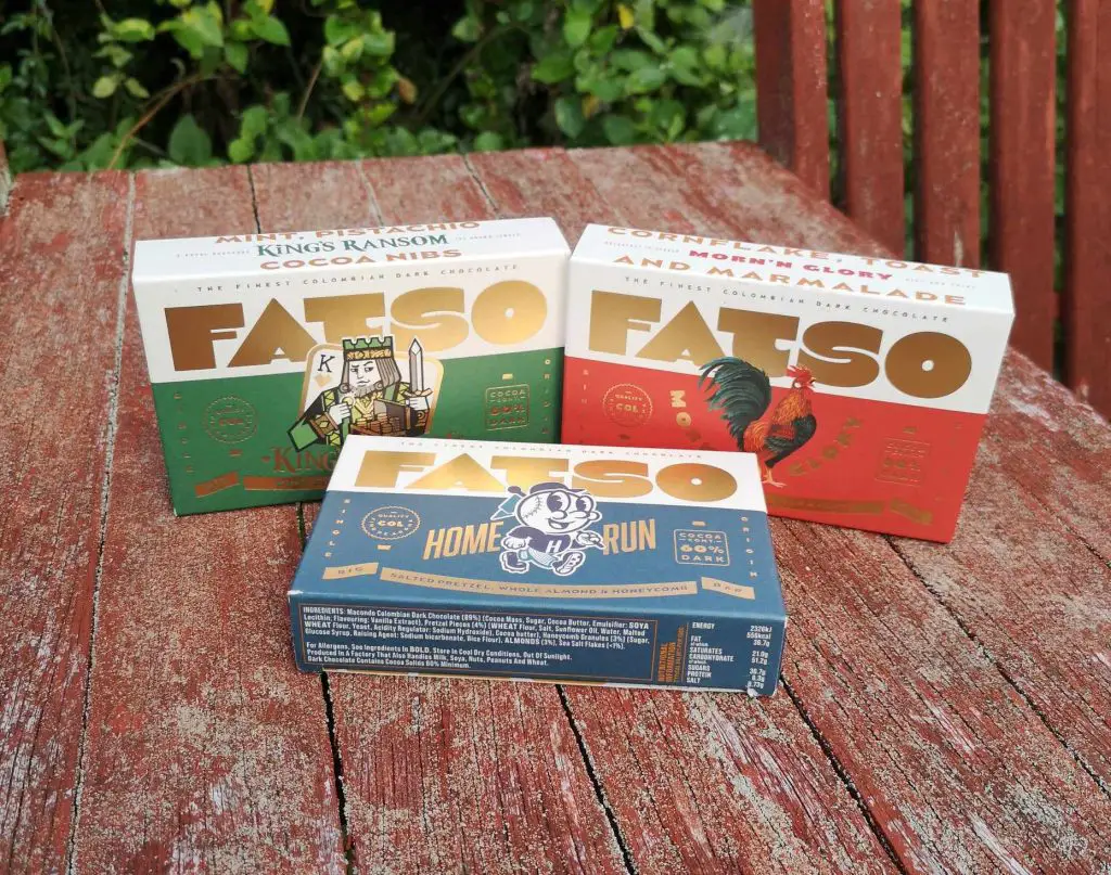 Three boxes of FATSO chocolate, in 3 different flavours, displayed on a garden table.