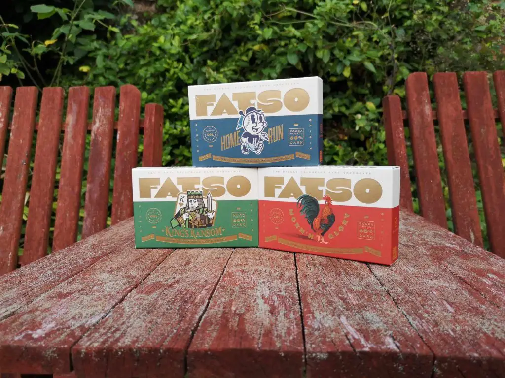 Three boxes of FATSO chocolate, in 3 different flavours, displayed on a garden table.