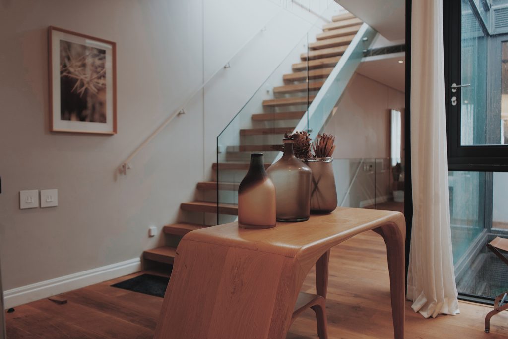 A modern looking staircase with wooden and glass decor around it.