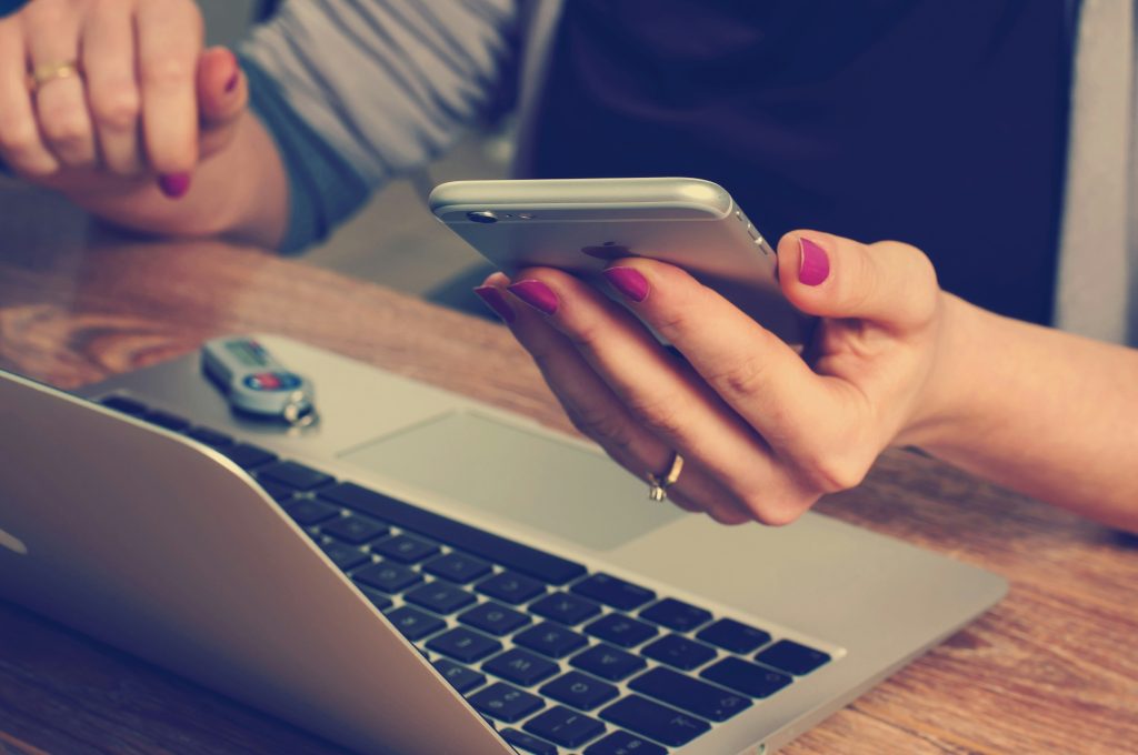 A person using their phone and laptop.
