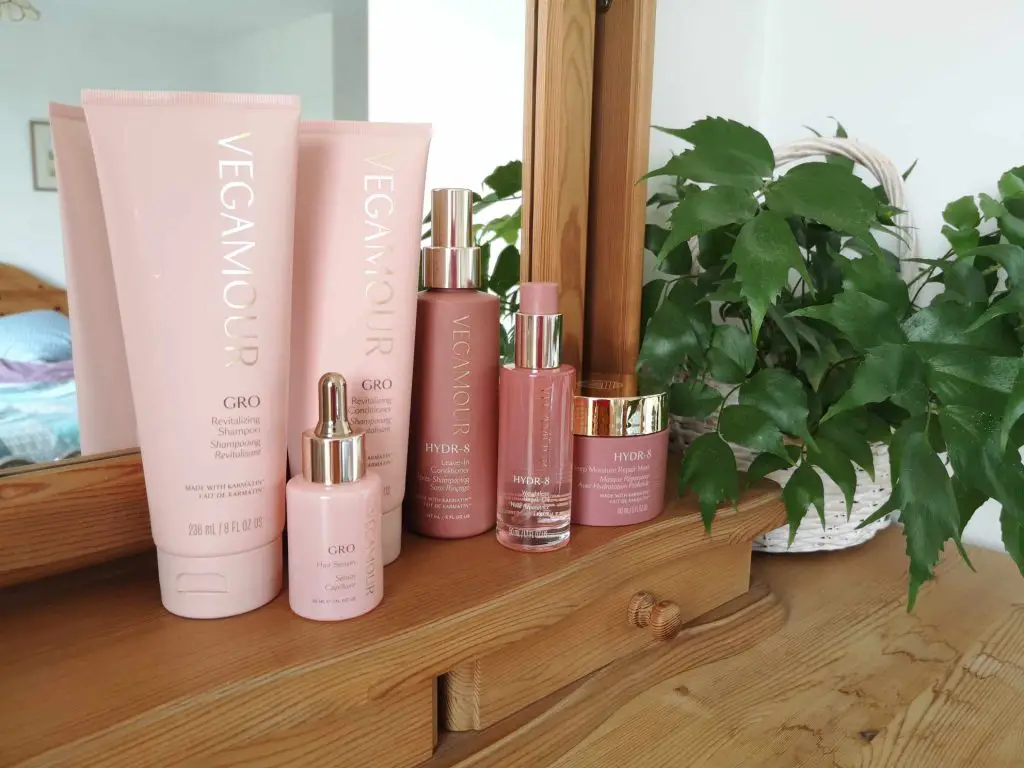 Six Vegamour hair products displayed on a dressing table.