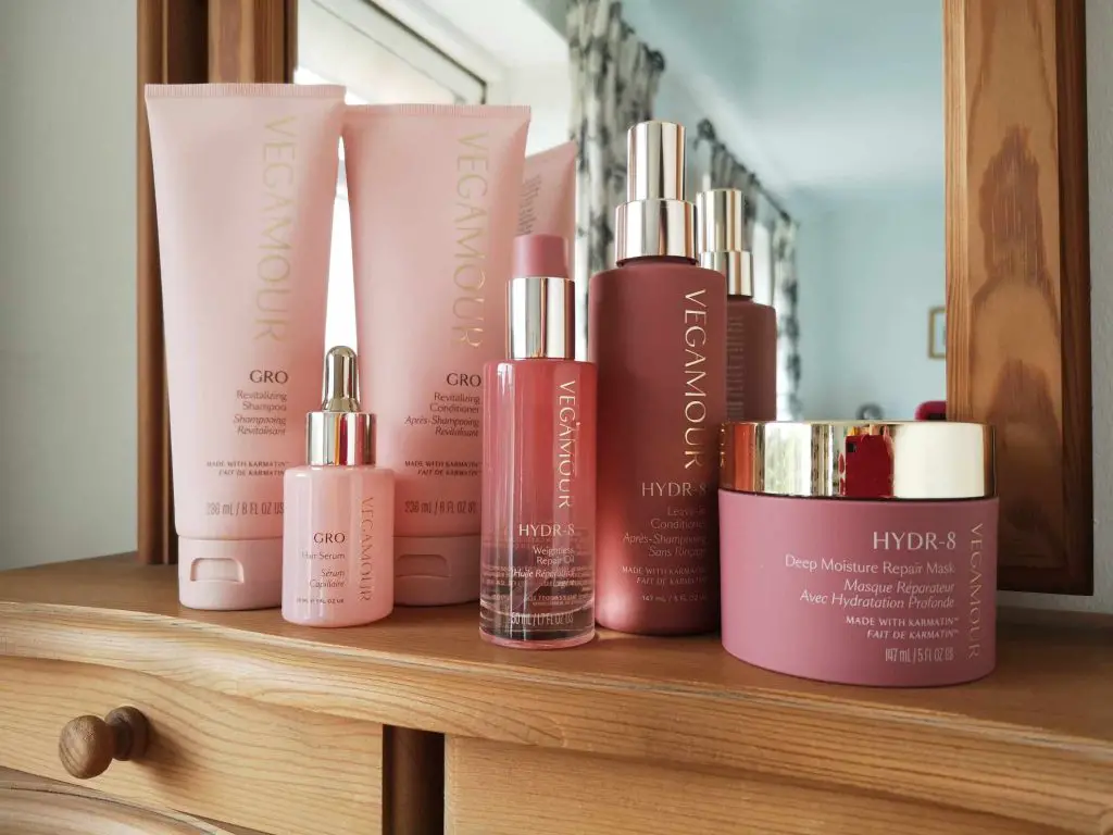 Six Vegamour hair products displayed on a dressing table.