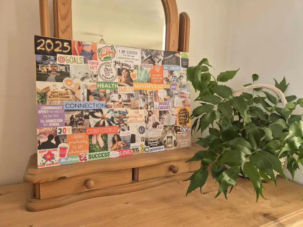 A completed vision board, propped up on a dressing table with a plant next to it.