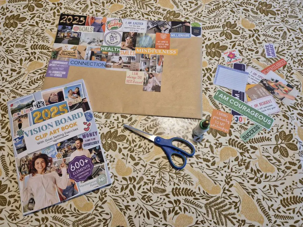 A vision board in progress, surrounded by cut-out images, scissors and glue.