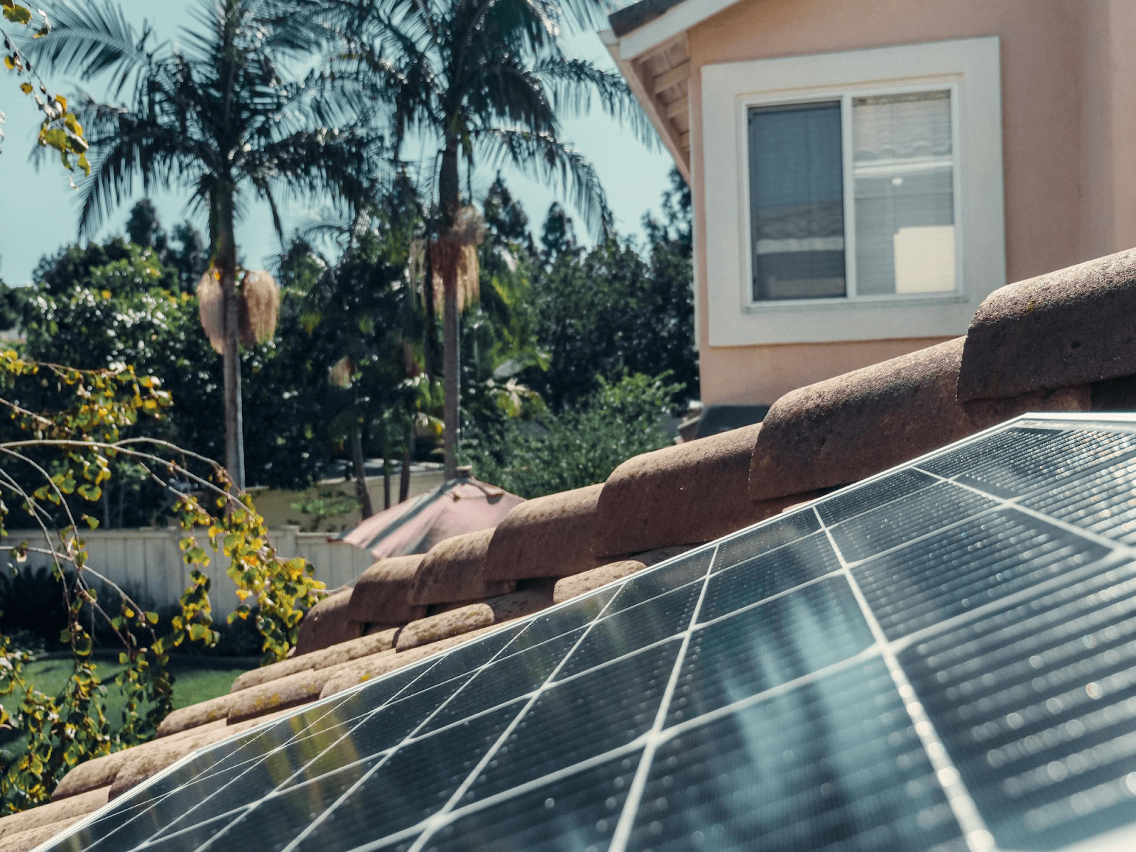 A tile roof with attractive blue solar panels on it.