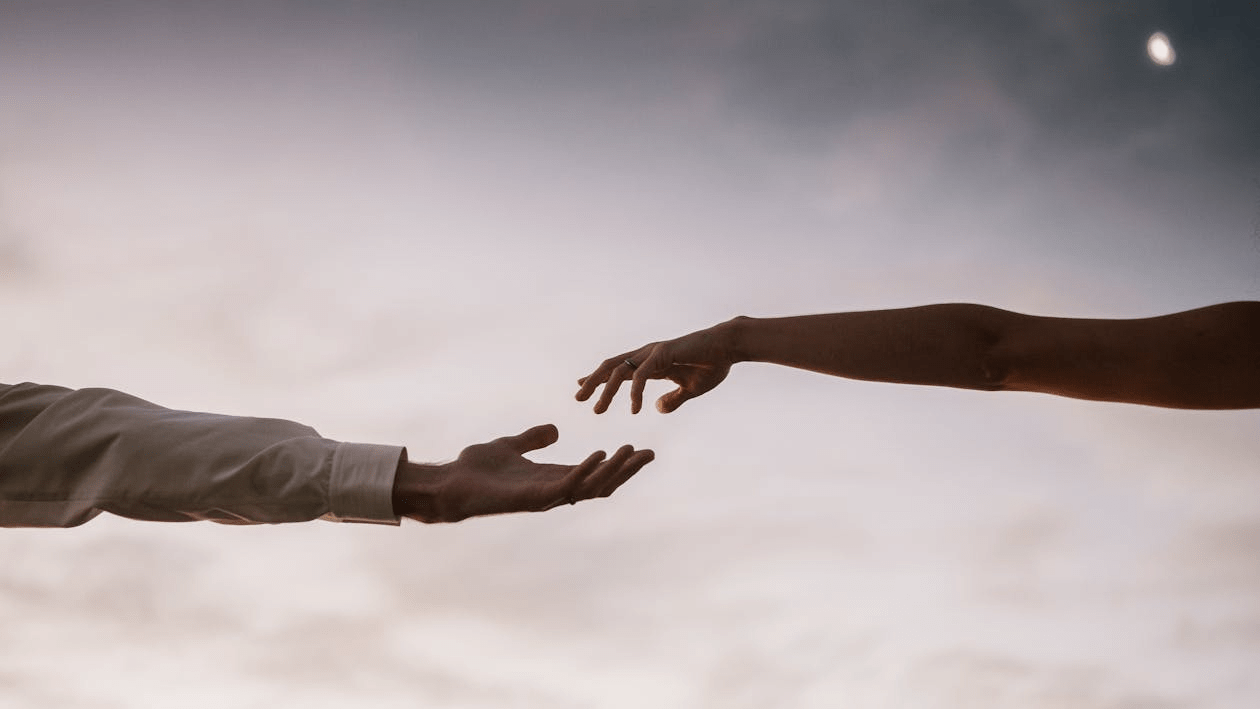 Two hands reaching out towards each other.