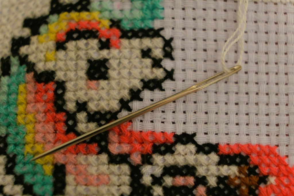 A close up view of a unicorn cross stitch.